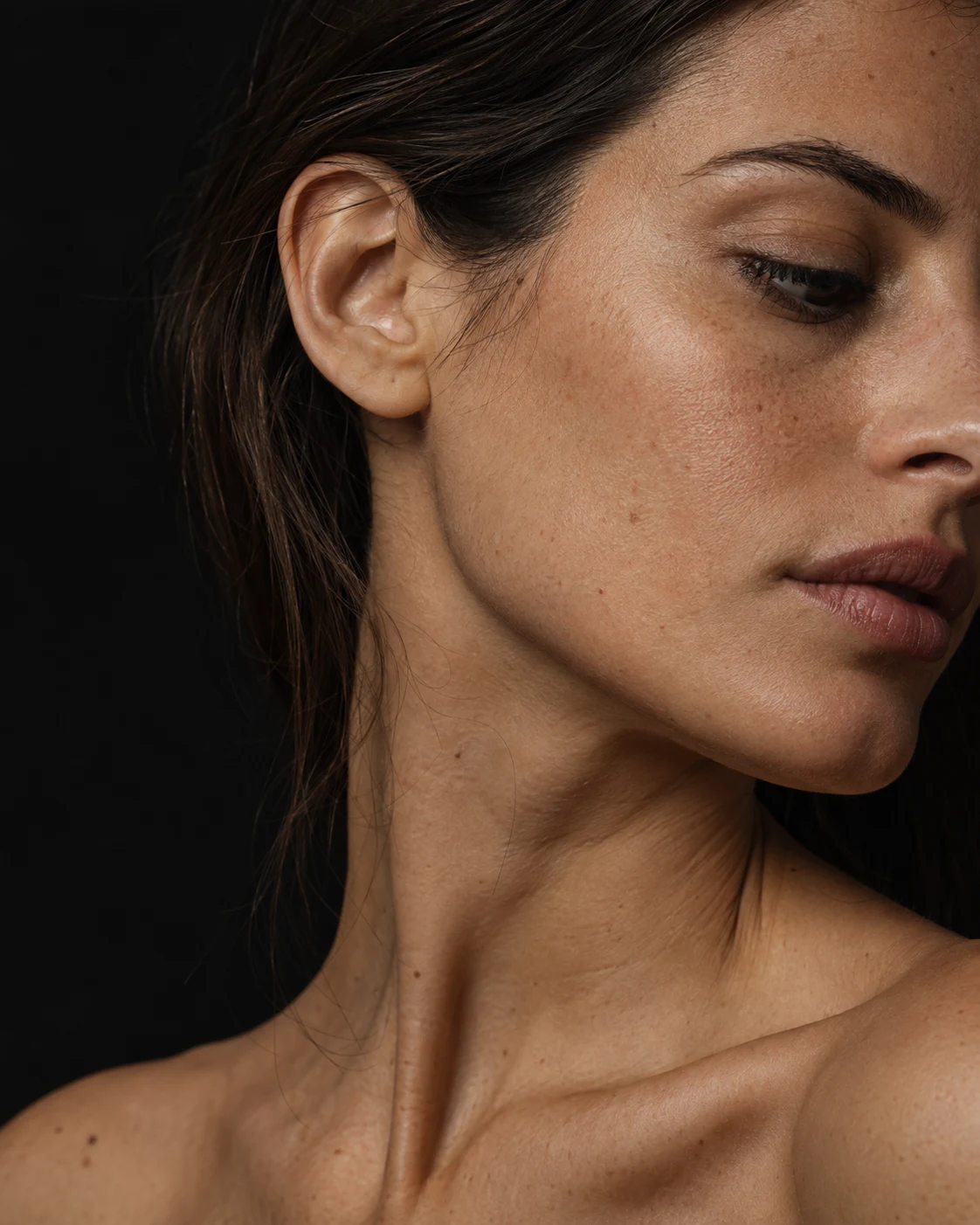 Natural close detail of a woman's cheek, jawline, and neck with visible skin texture